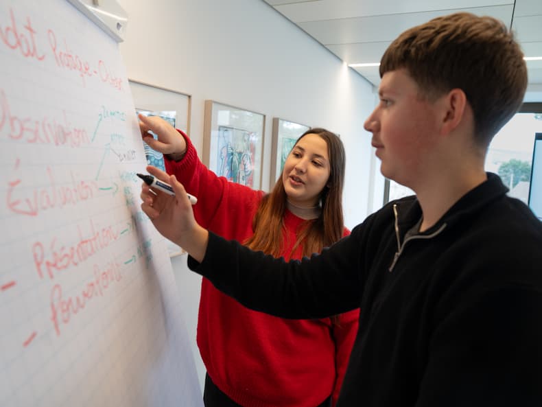 deux jeunes travaillent ensemble