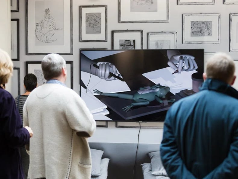 Visiteurs devant les écrans de l’exposition «L’art et le développement durable à la Mobilière» 