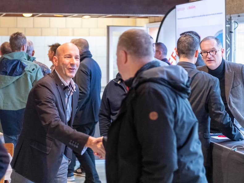 Deux personnes se saluent et se servent la main.