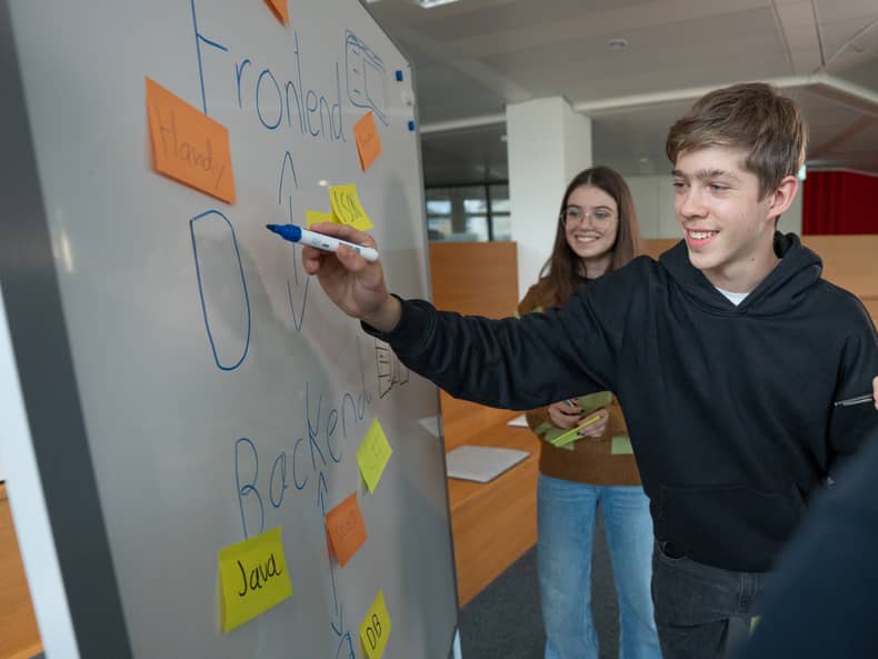 Jugendliche planen an einem Whiteboard