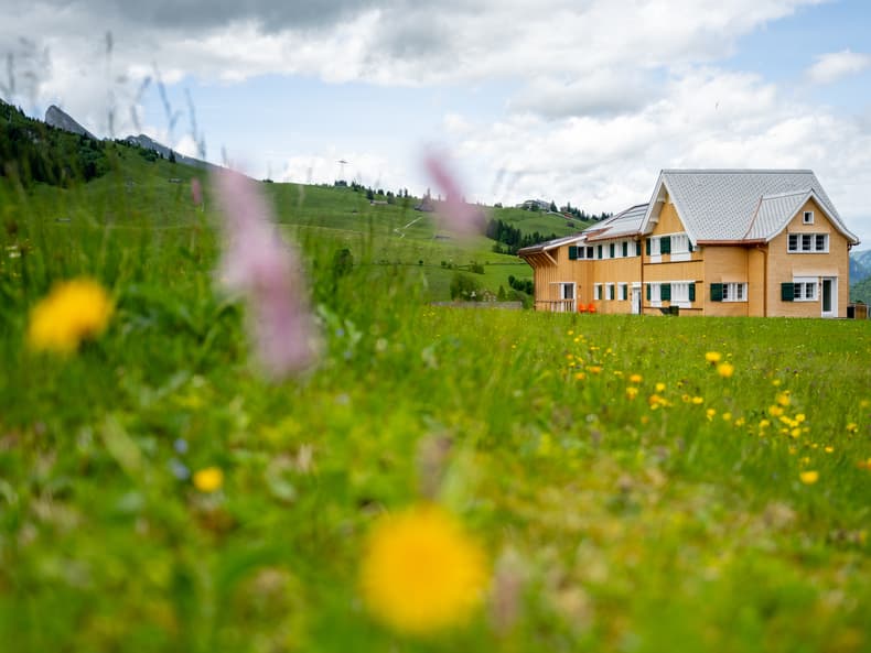 Das Gruppenhaus JENNYHAUS von Berg & Bett, davor eine grüne Wiese.