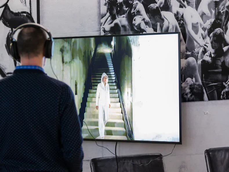 Un homme avec des écouteurs dans l’exposition «L’art et le développement durable à la Mobilière» 