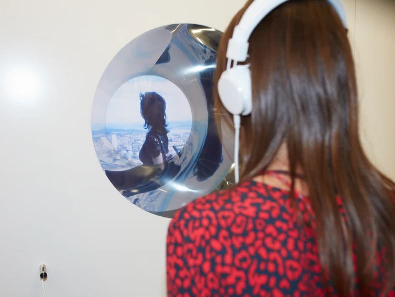 Femme avec des écouteurs en face d’une balle ronde miroir