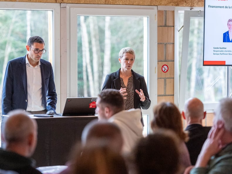 Deux personnes font une présentation devant un public.