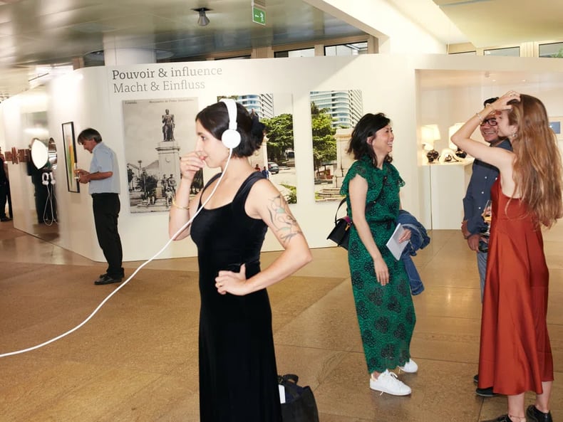 Une femme avec des écouteurs dans l’exposition «L’art et le développement durable à la Mobilière»