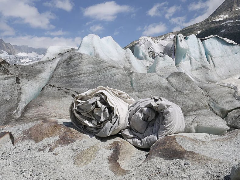 zwei Stoffrollen liegen vor dem Gletscher in der Ausstellung Kunst und Nachhaltigkeit in der Mobiliar 