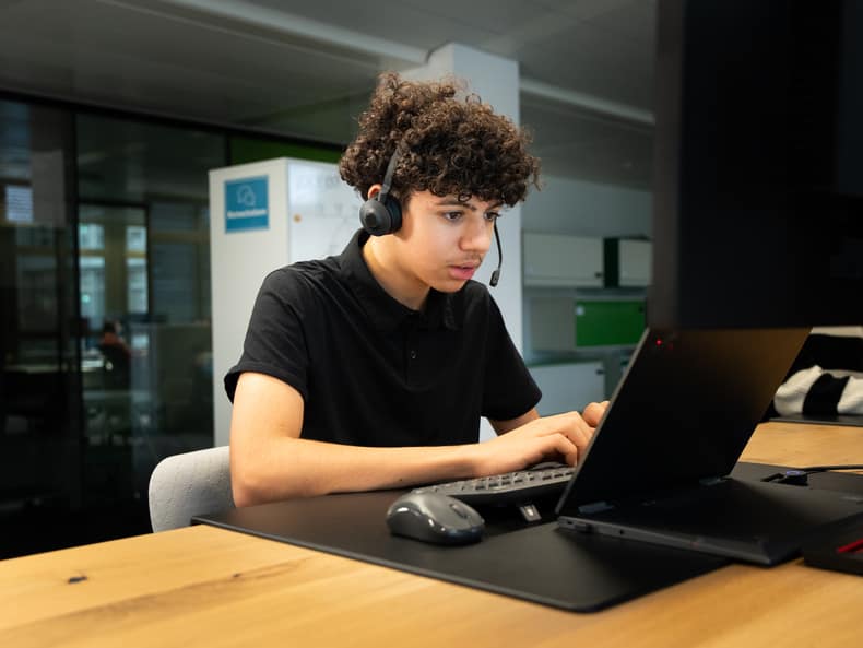 Jugendlicher mit Headset sitzend am PC