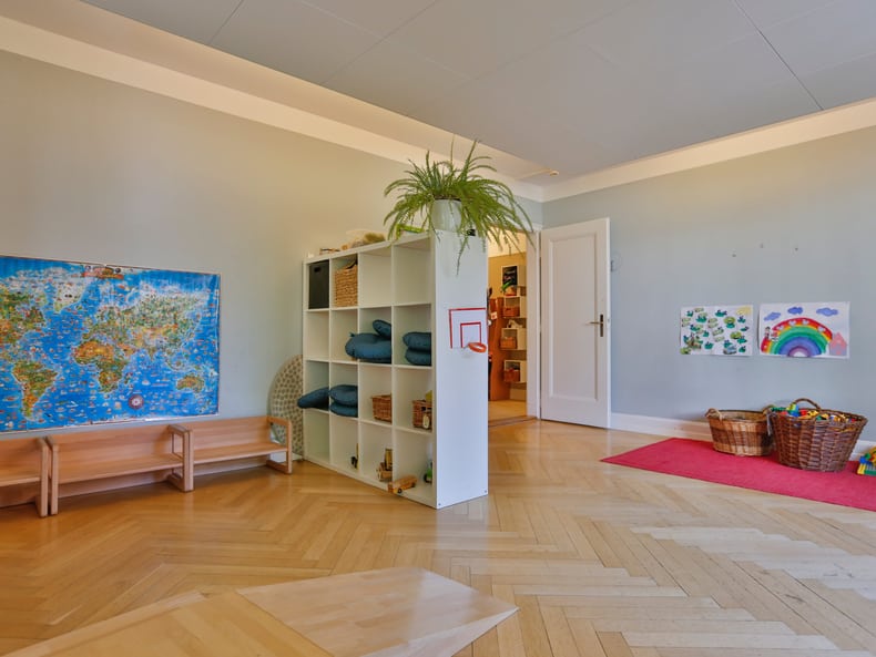 Ein Zimmer mit einem Regal und Karten und Zeichnungen an der Wand