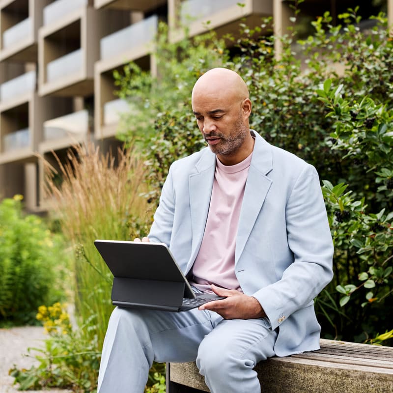 Mann im Park mit einem Laptop