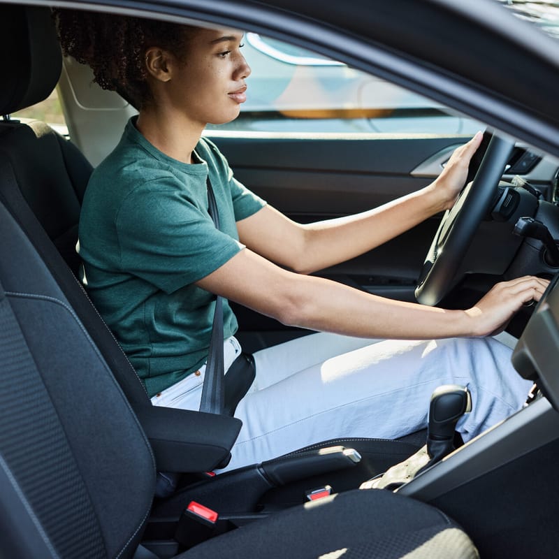 Giovane donna al volante di un’automobile