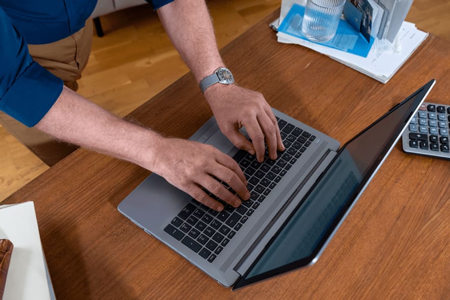 Frau tippt auf einem Laptop.
