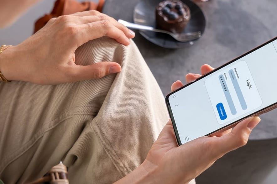 Hände halten ein Smartphone.