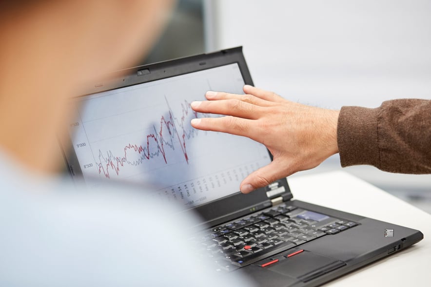 Due persone discutono di qualcosa che vedono sullo schermo di un computer portatile. 