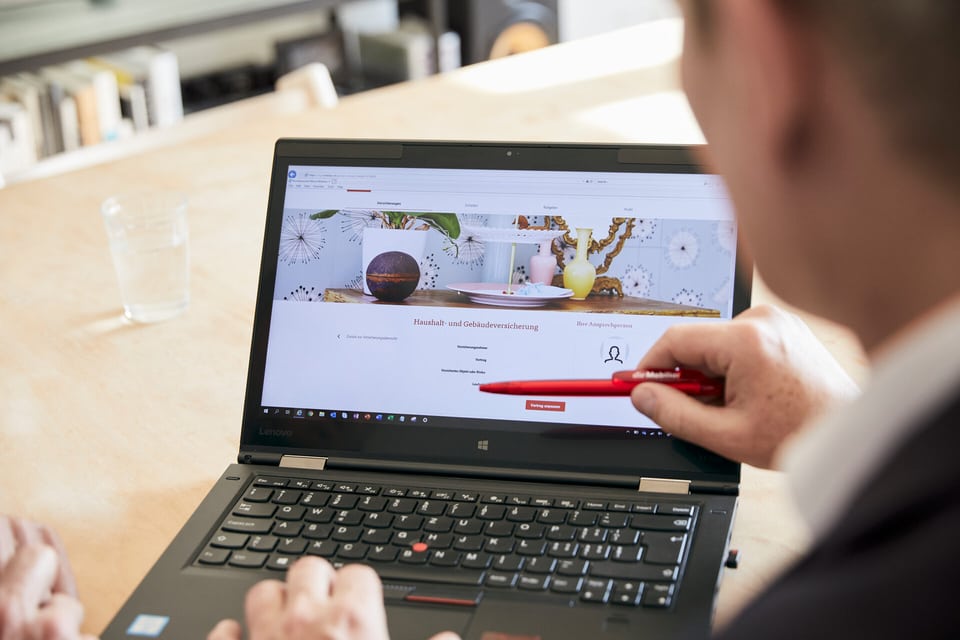 Ein Mann zeigt auf einen Laptop-Bildschirm.