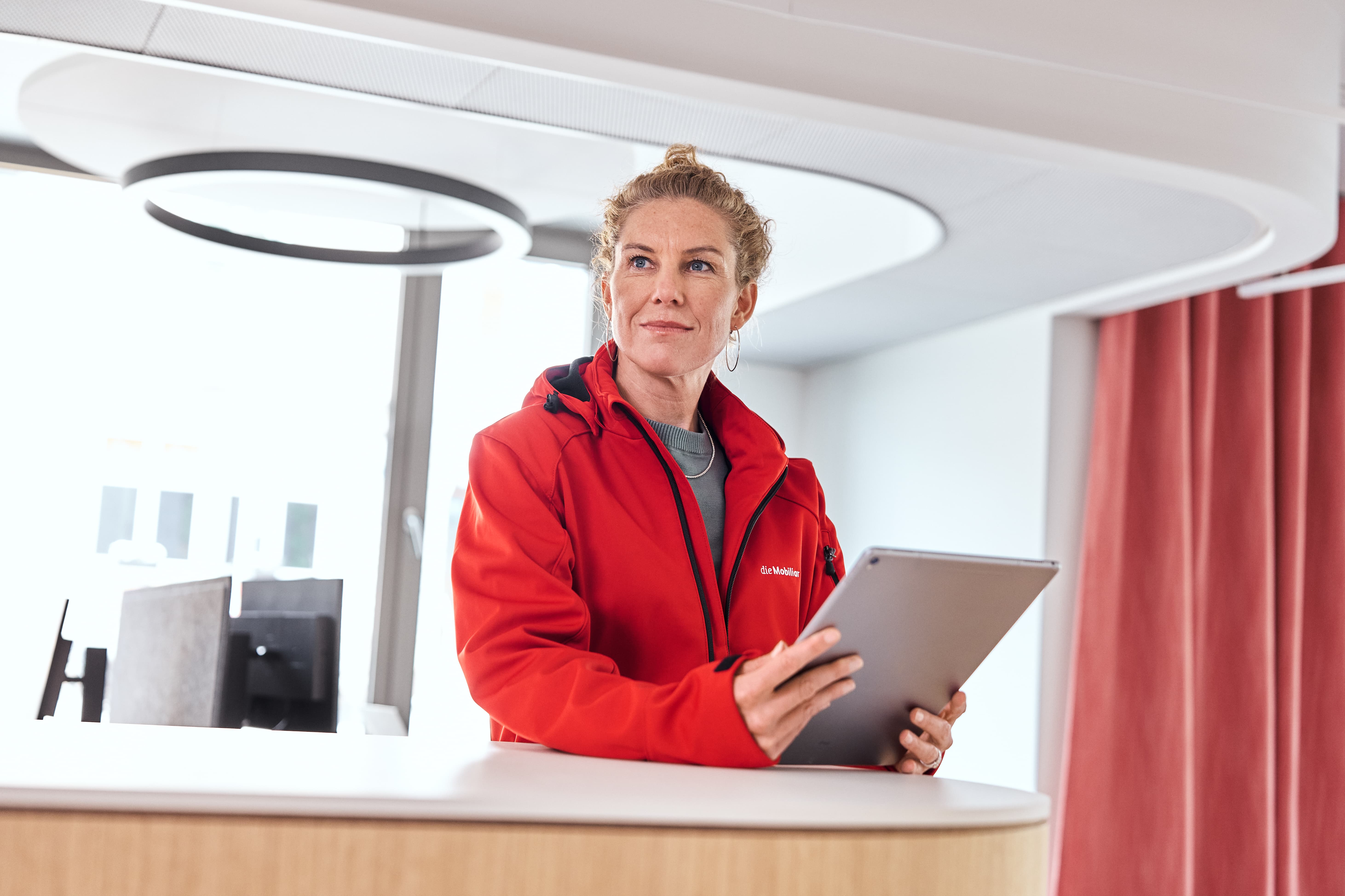 Mitarbeiterin mit Tablet am Stehpult