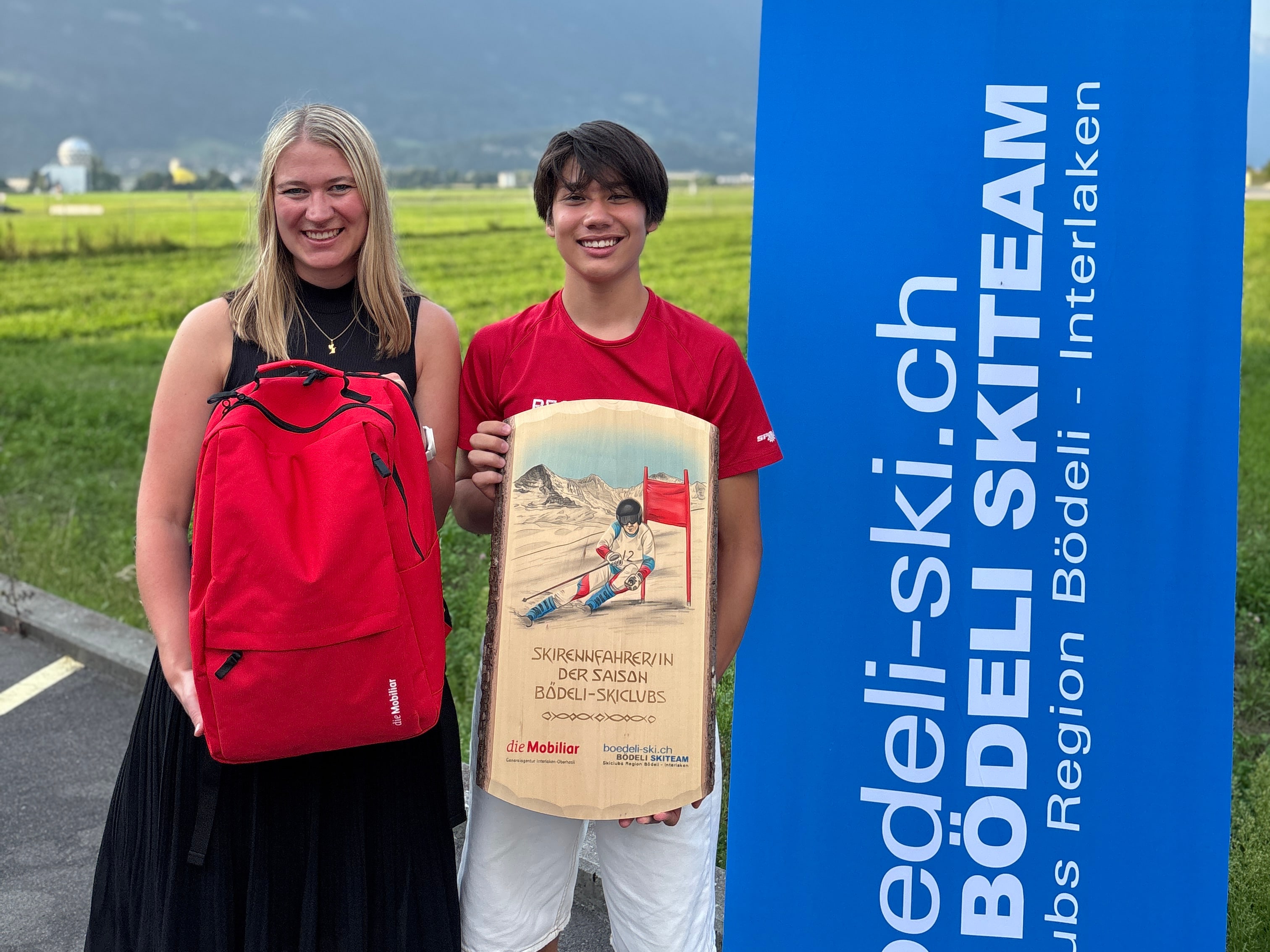 Jessica Fuhrer steht mit einem Mobiliar-Rucksack neben Stefan Ploner