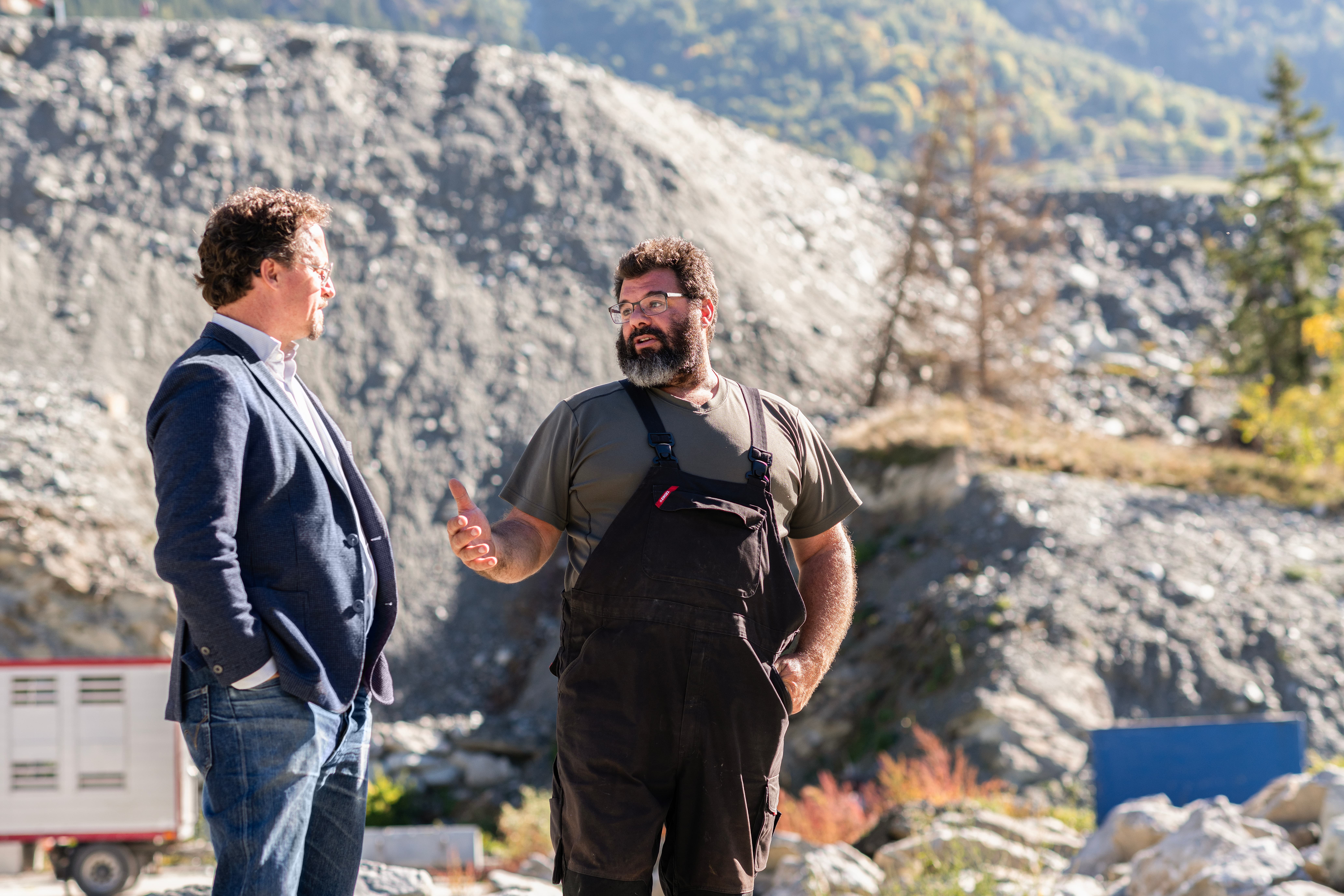 Lucien Fellay et Christophe Gailland, son conseiller en assurances, sont en pleine conversation devant les décombres de la maison du paysan.