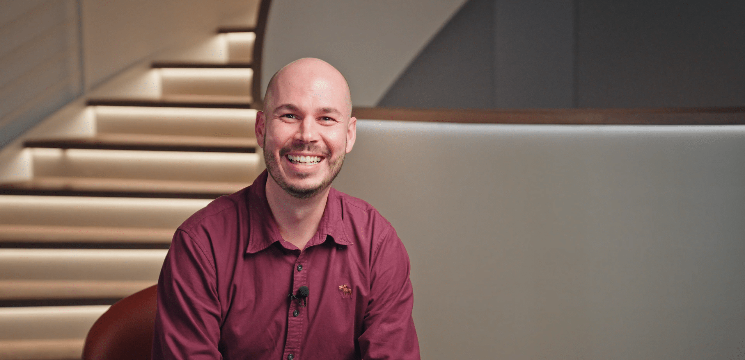 Mitarbeitender sitzt vor einer Treppe