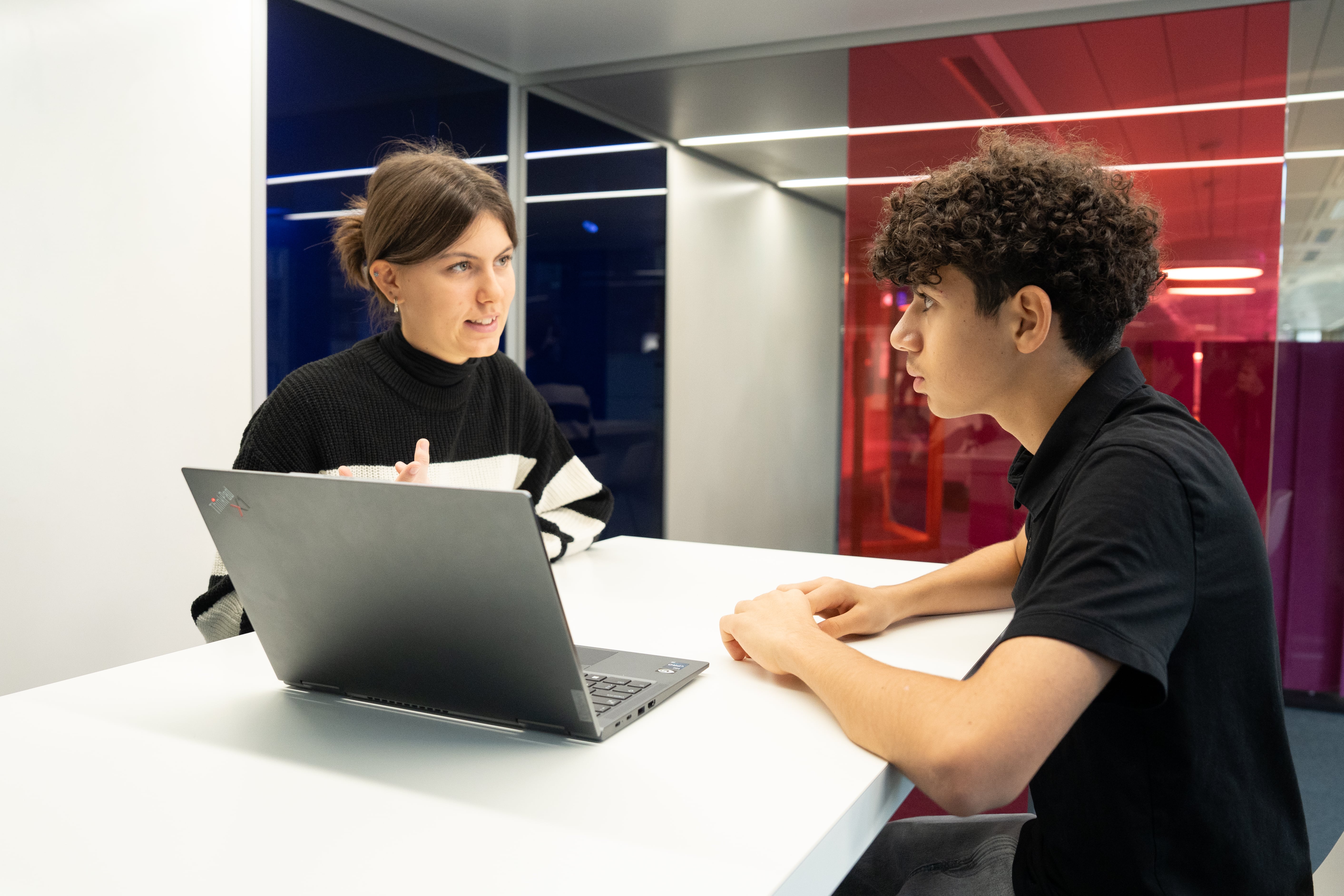 Zwei Jugendliche führen eine Besprechung sitzend