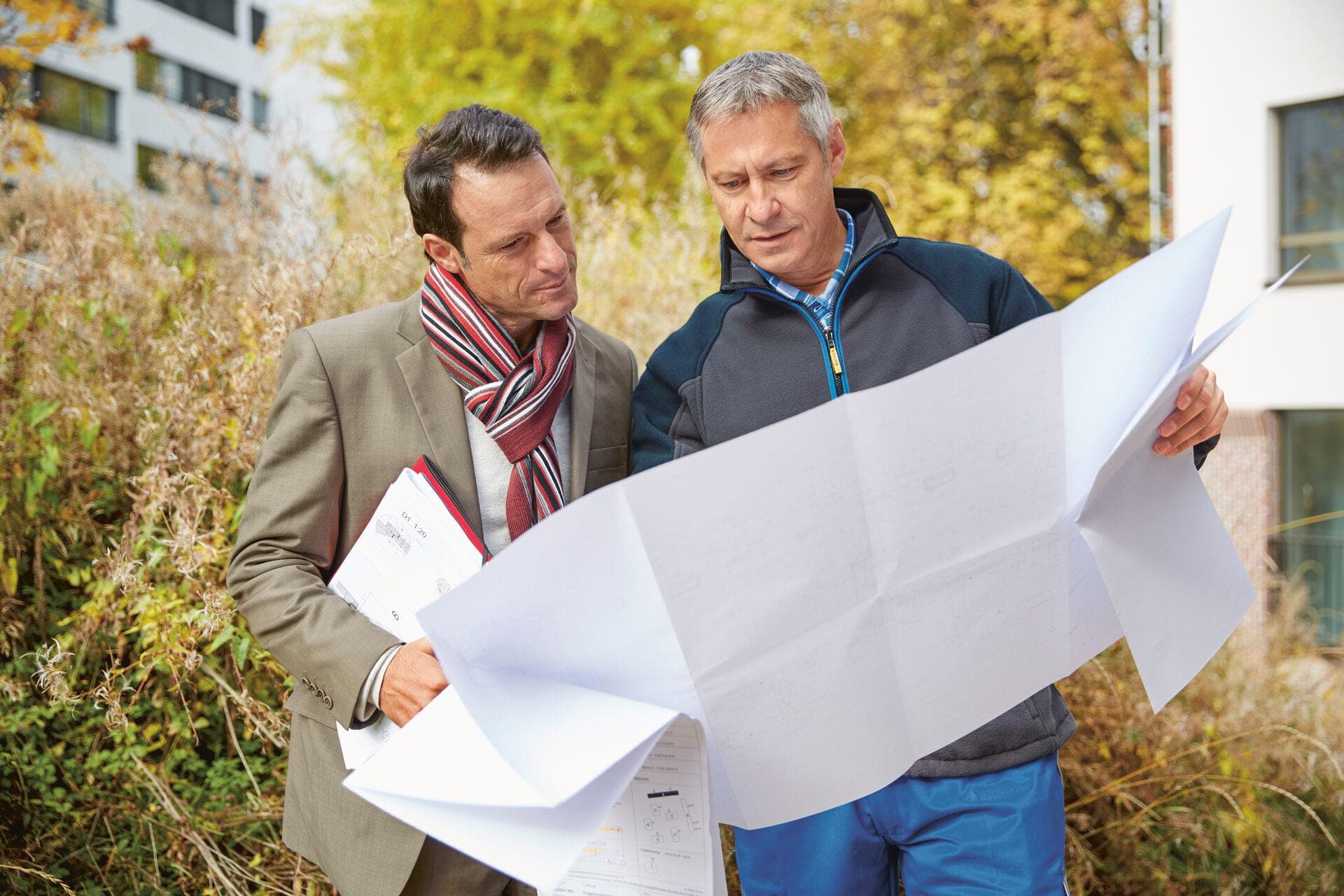 Zwei Männer inspizieren einen Bauplan