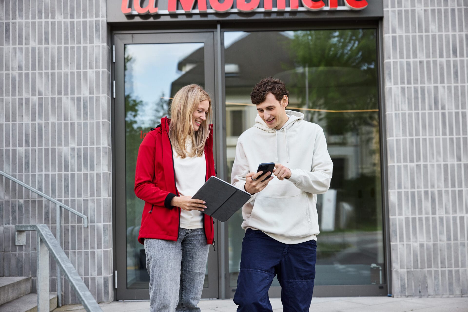 Zwei junge Personen vor einem Eingang einer Mobiliar Generalagentur