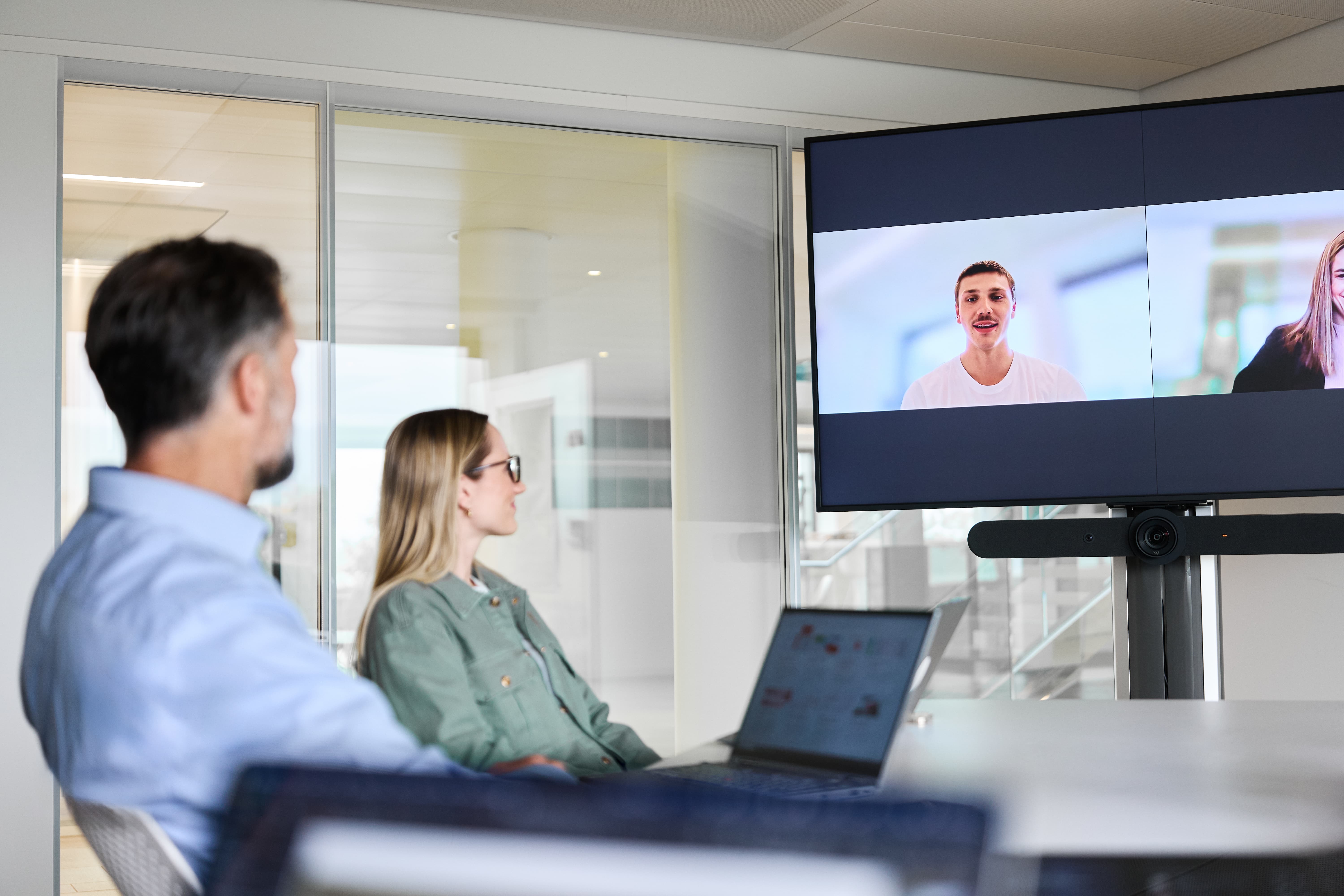 Mitarbeitende haben ein Meeting vor Ort und Remote
