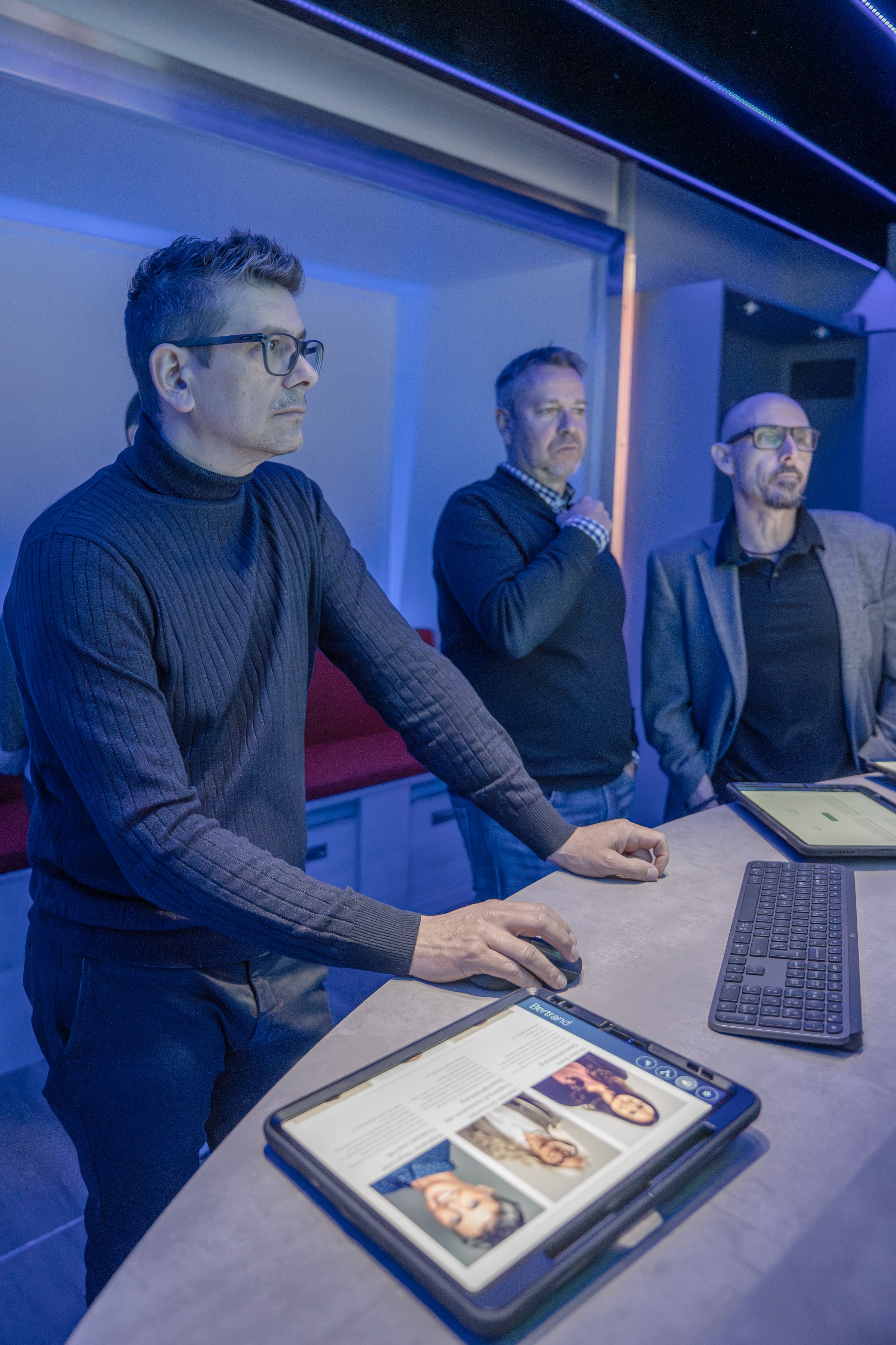 Blick in den Anhänger von Cyber  on Tour der Mobiliar. Eine Gruppe von Menschen ist dabei sich zum Thema Cybersicherheit weiterzubilden.