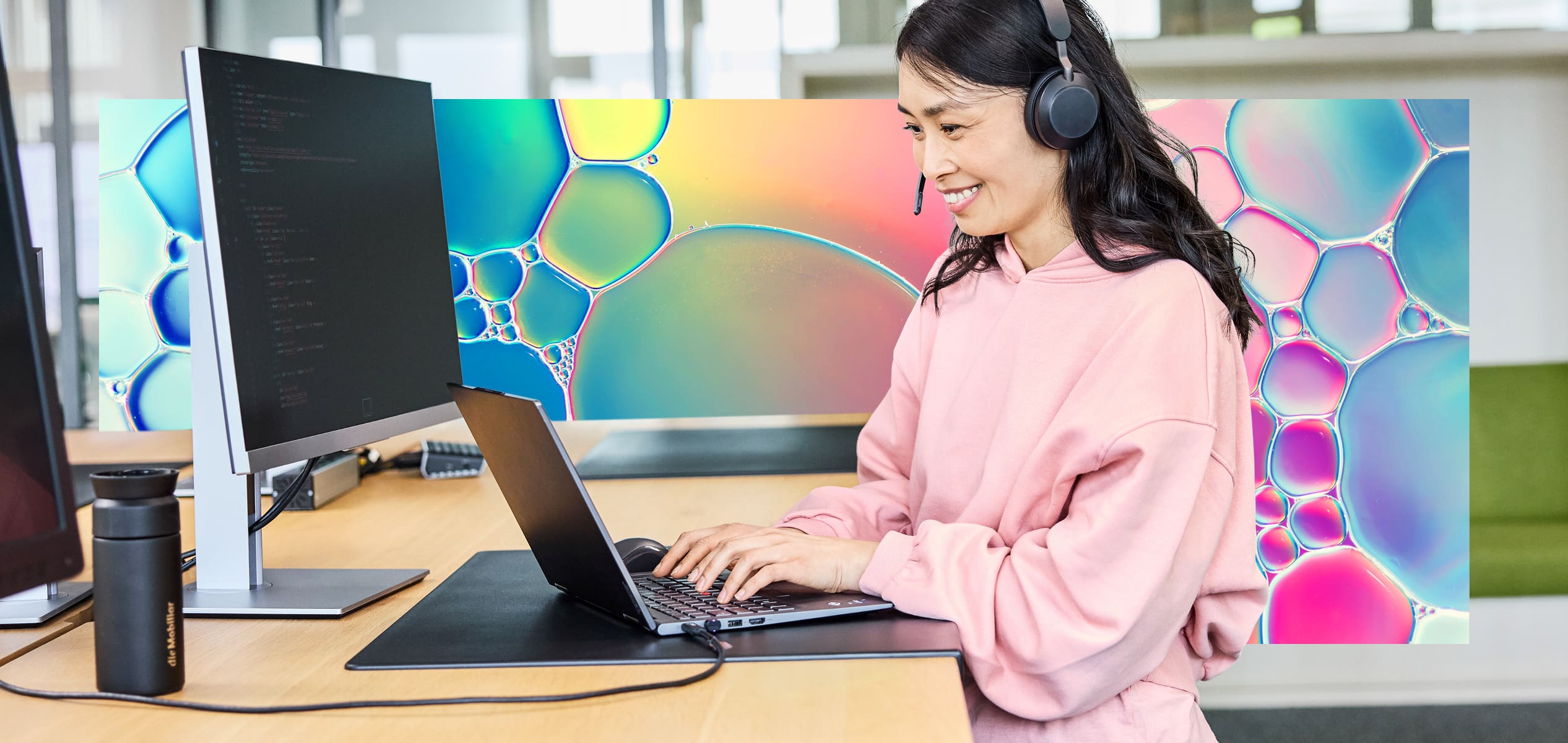 Ein Frau an einem hohen Holztisch am Notebook