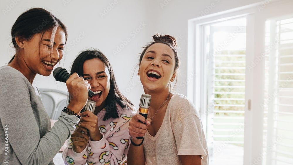 Drei Frauen singen in ein Mikrophon.