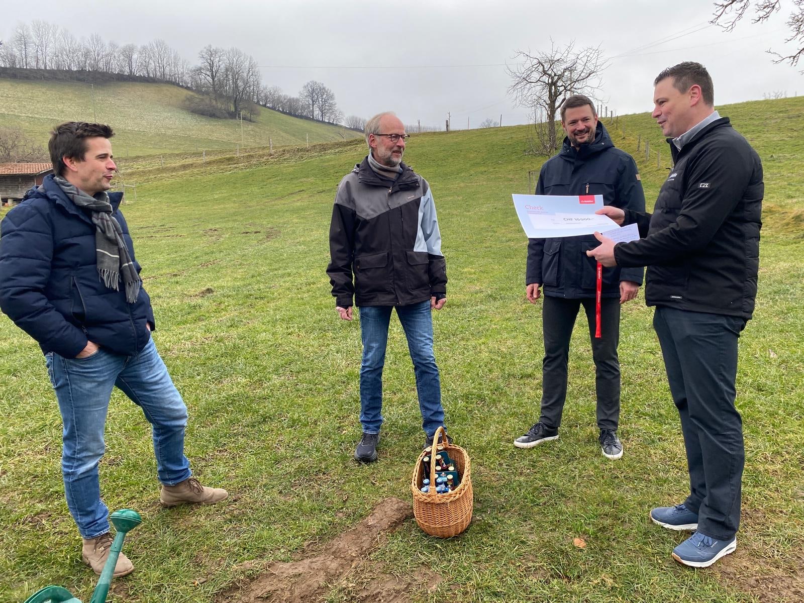 Die Co-Präsidenten des Jubiläums-OK Urs Rohrbach (links) und Ruedi Flückiger (2. von links) nehmen den Check von  Andrew Geissbühler, Agenturleiter der Mobiliar Schwarzenburg, in Empfang.