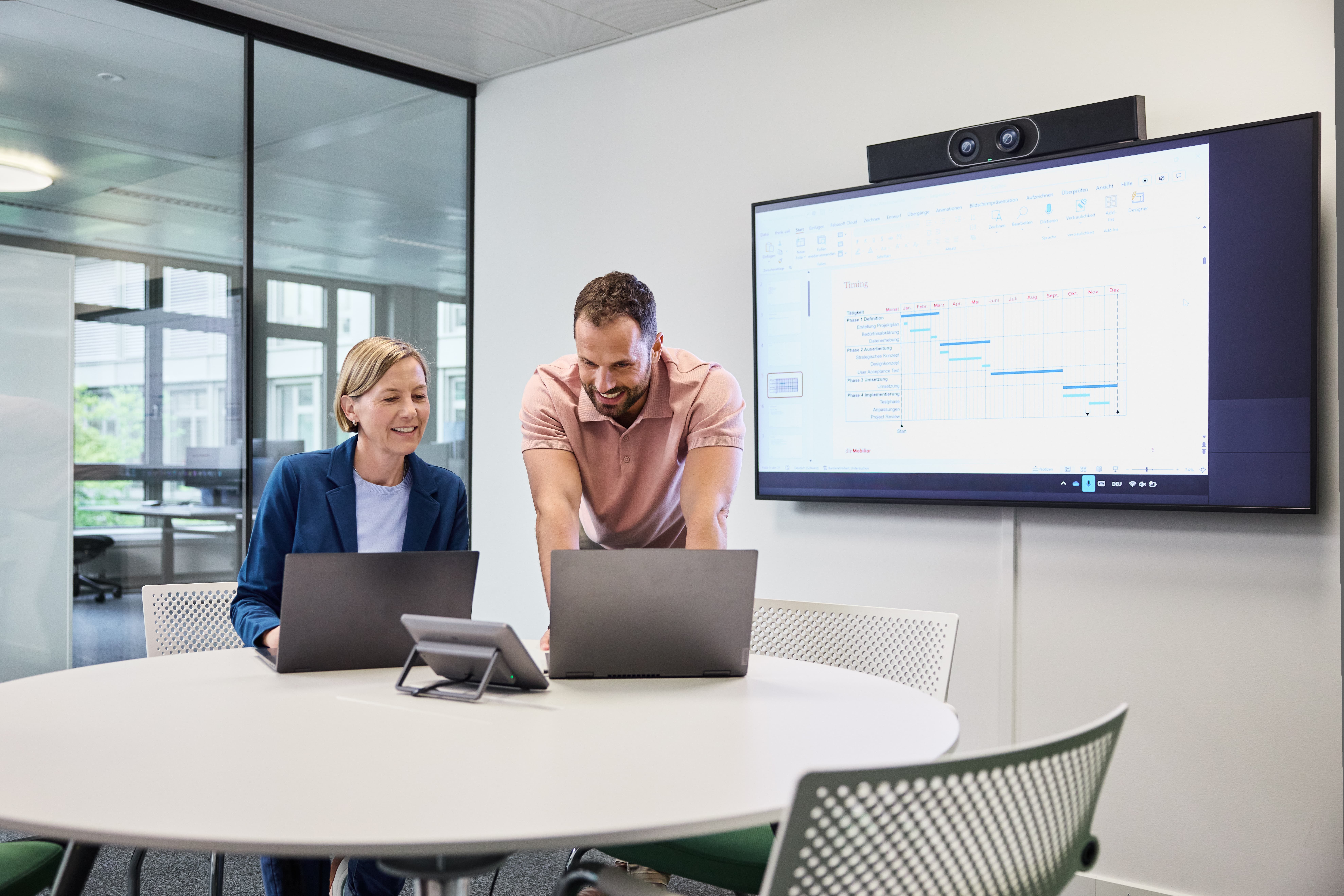 Trois personnes discutent autour d’une table haute.