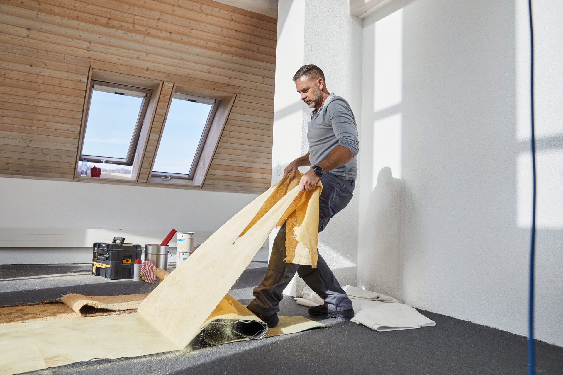 Ein Handwerker reisst einen Boden heraus.