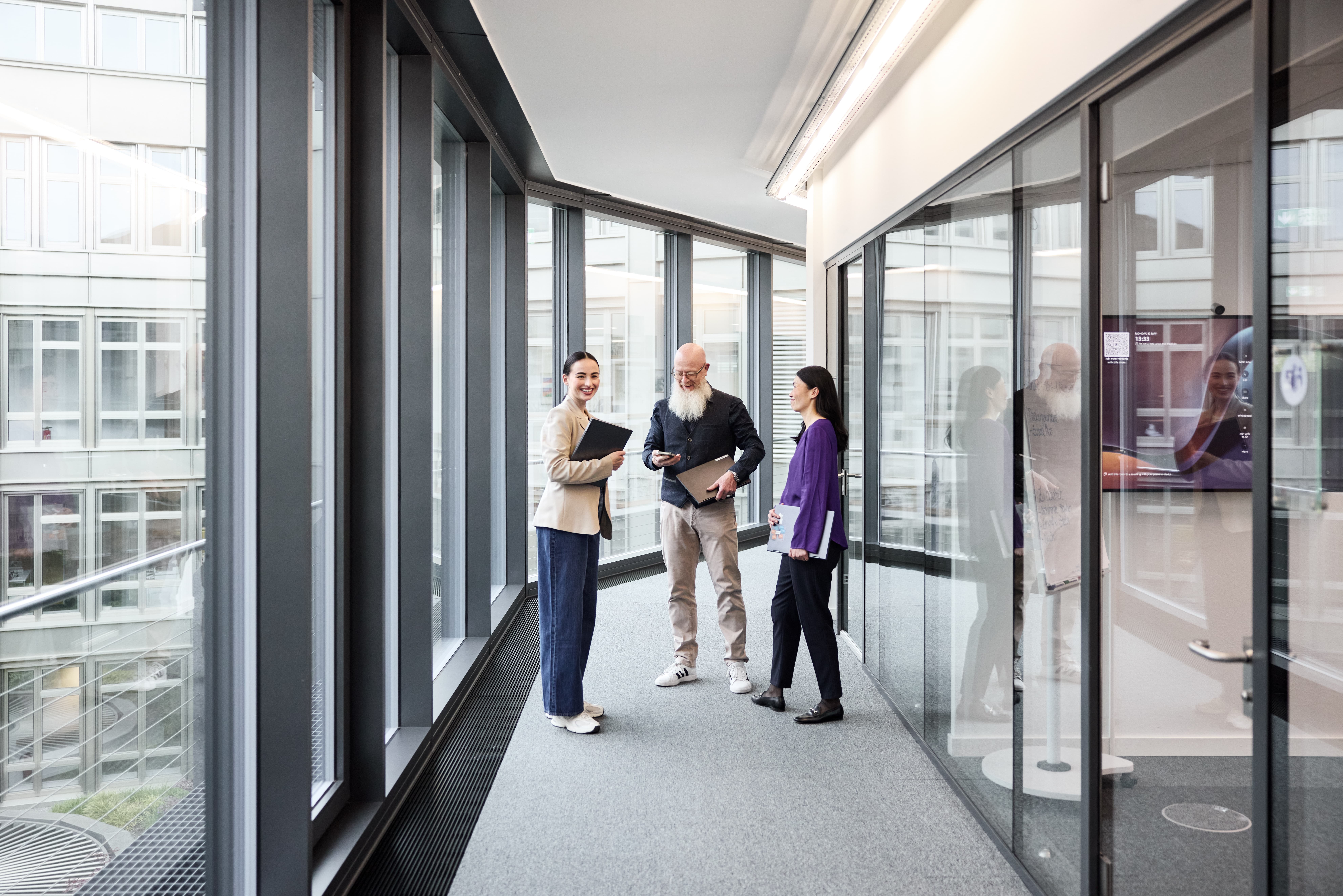 Mitarbeitende treffen sich im Korridor