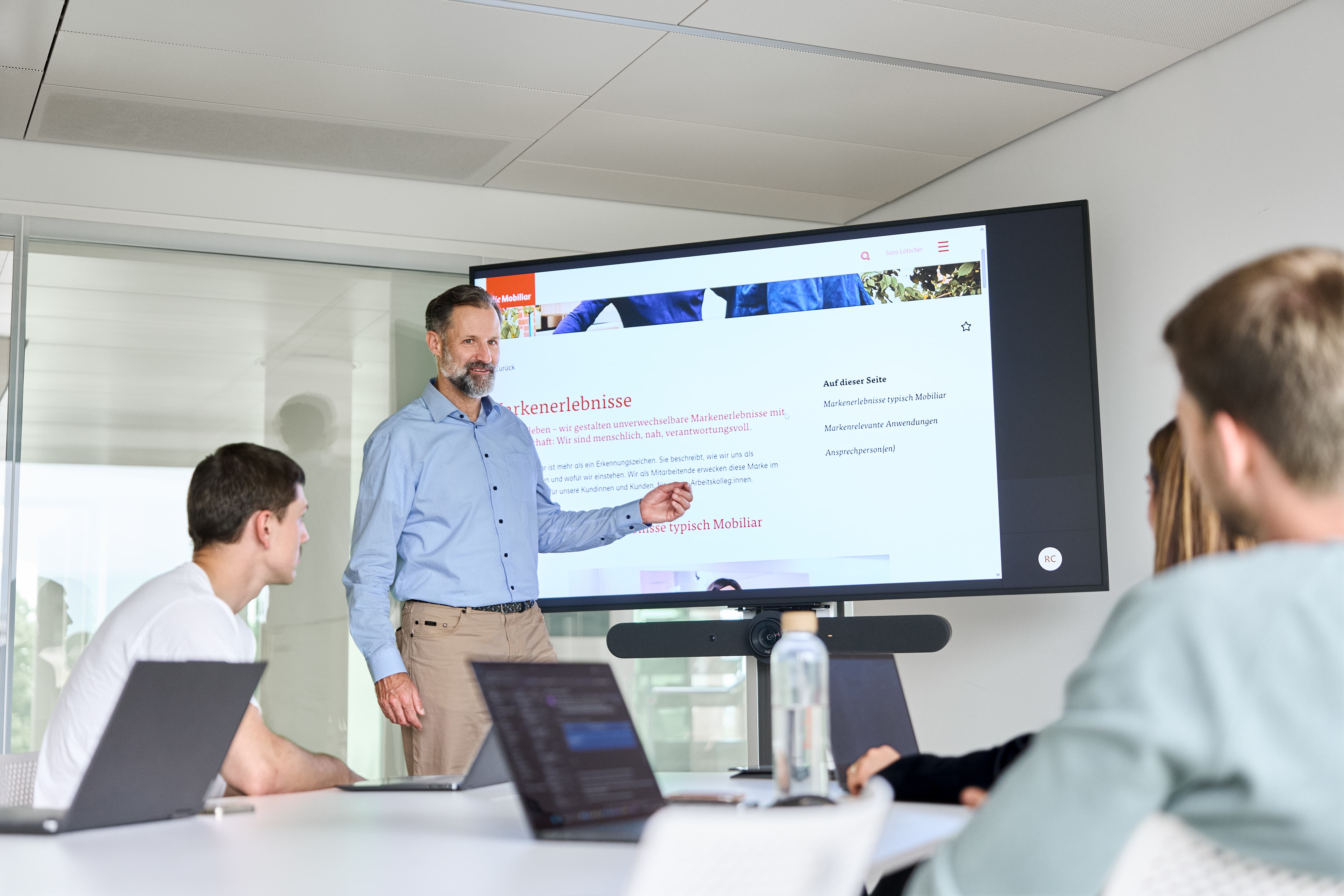 Le groupe discute de quelque chose à la table haute et regarde un laptop.