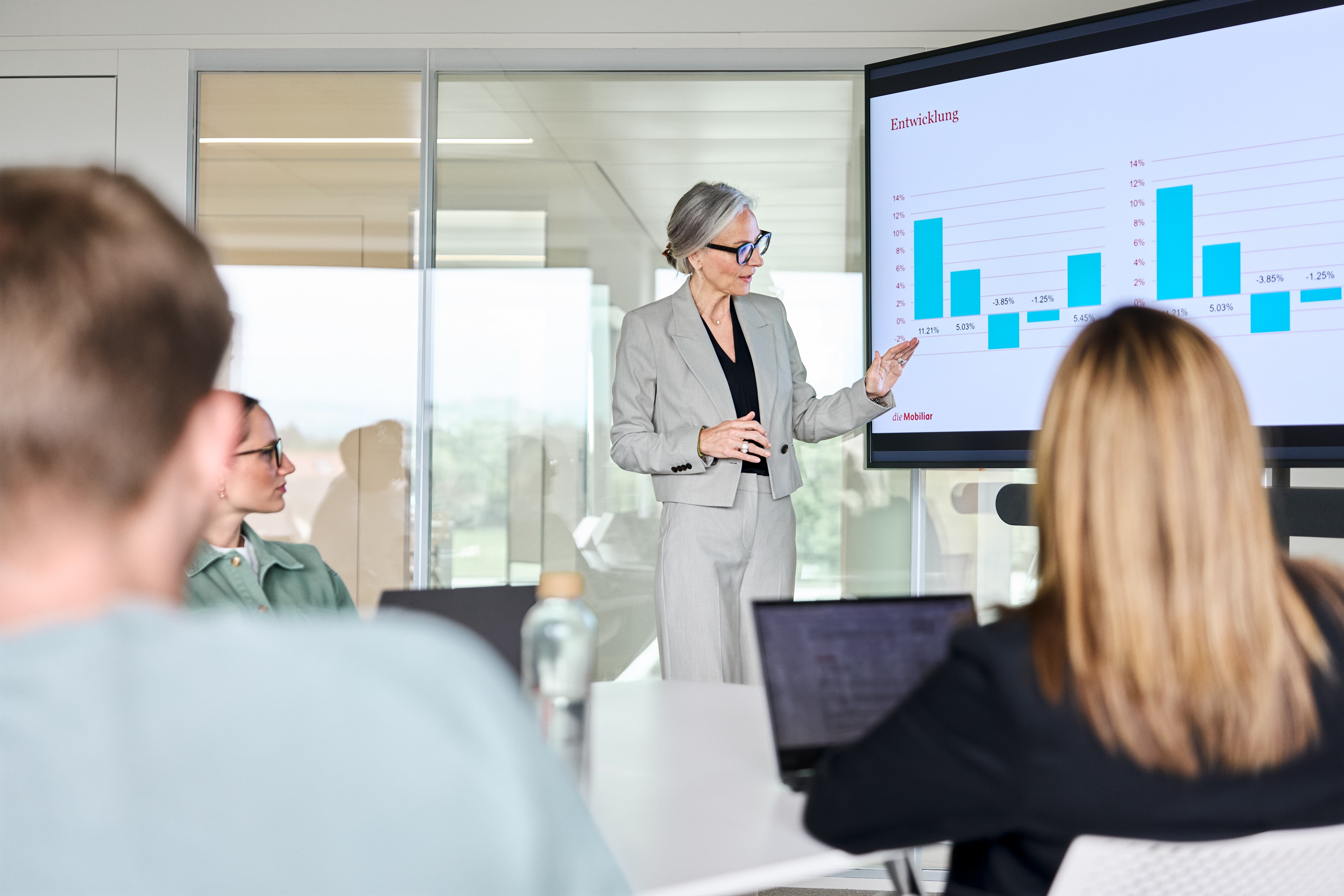 Mitarbeiterin präsentiert Statistiken auf dem Screen