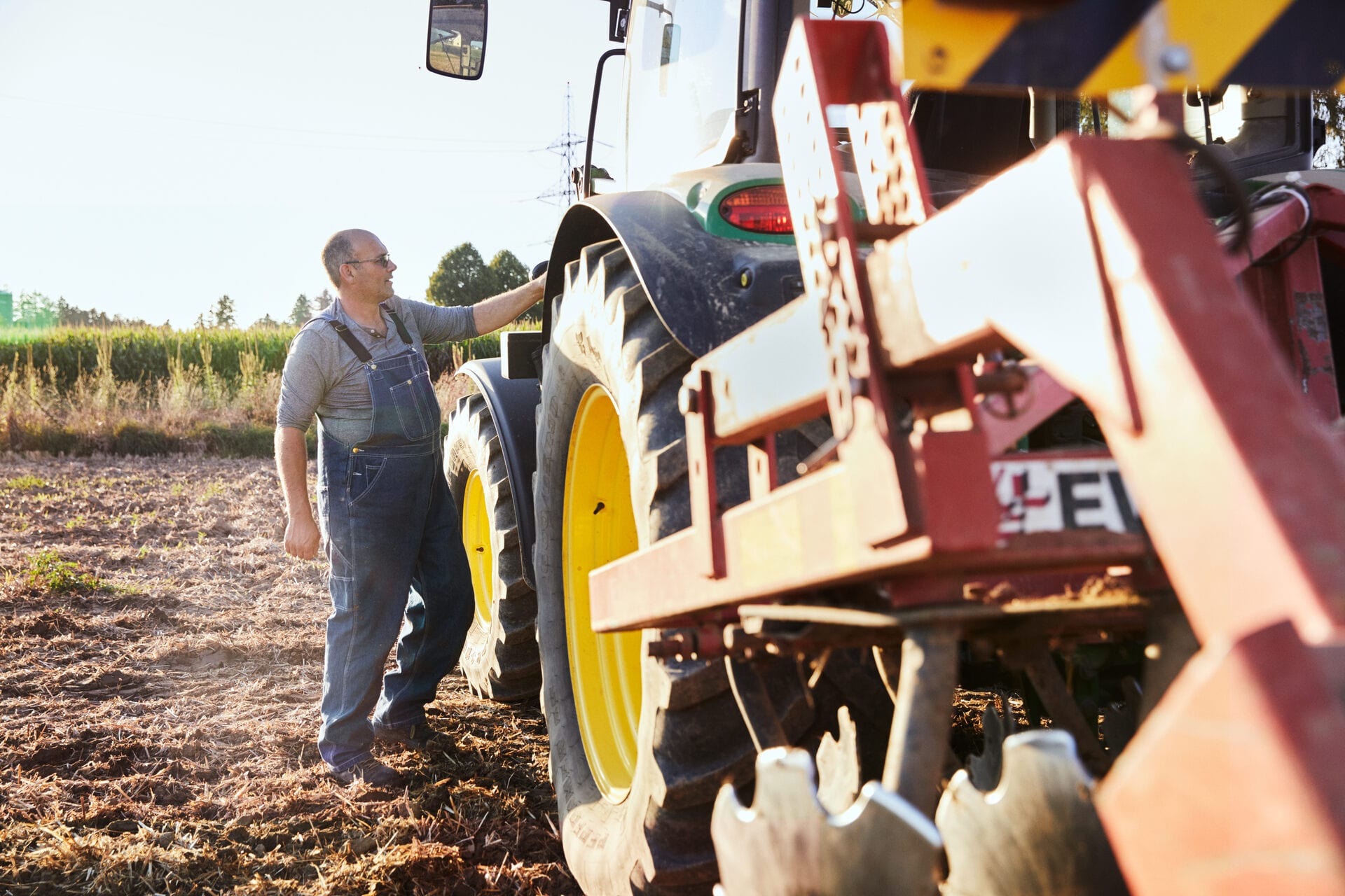 Un paysan avec un tracteur travaille dans le champ.