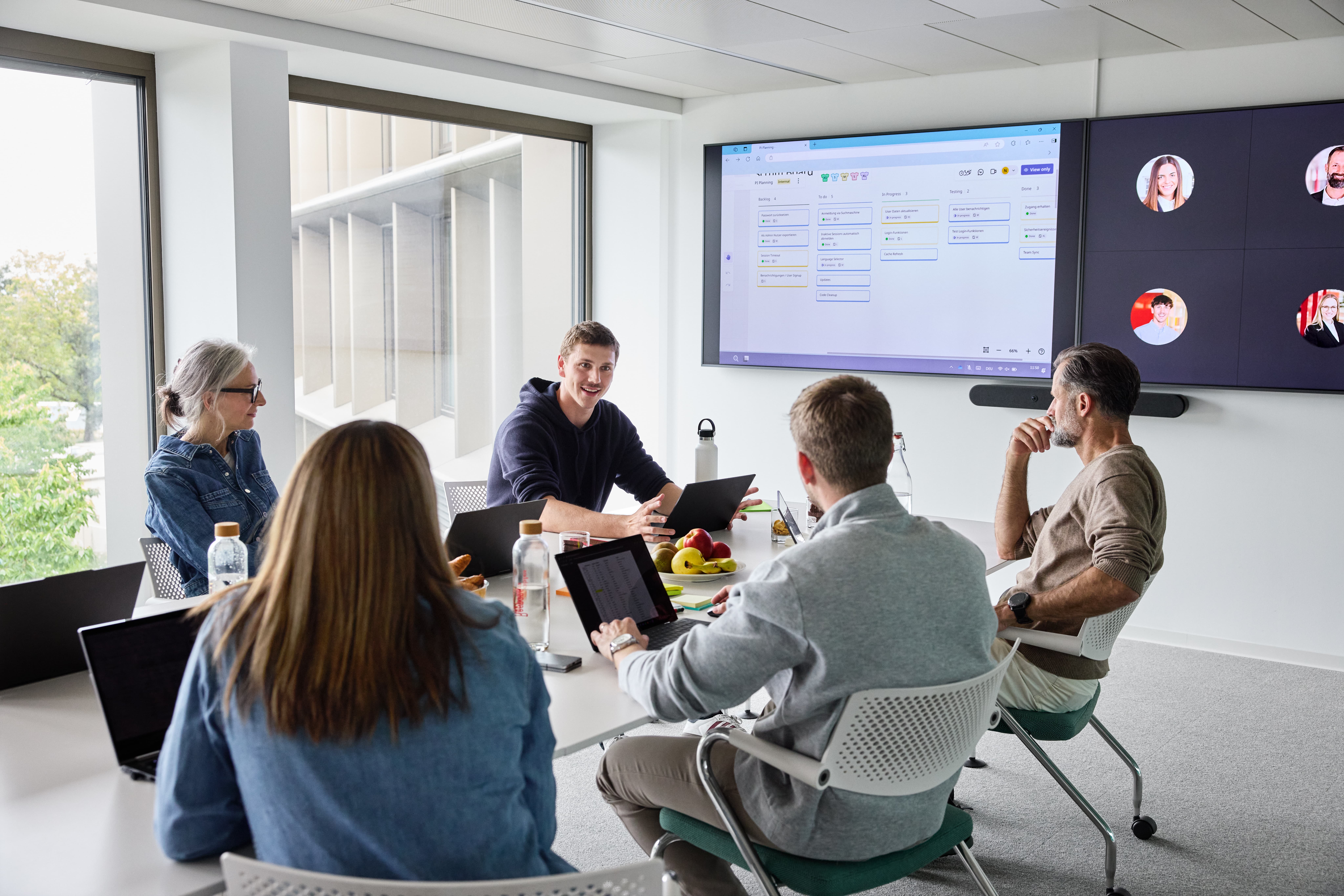 Teammeeting mit Präsentation am Bildschirm  