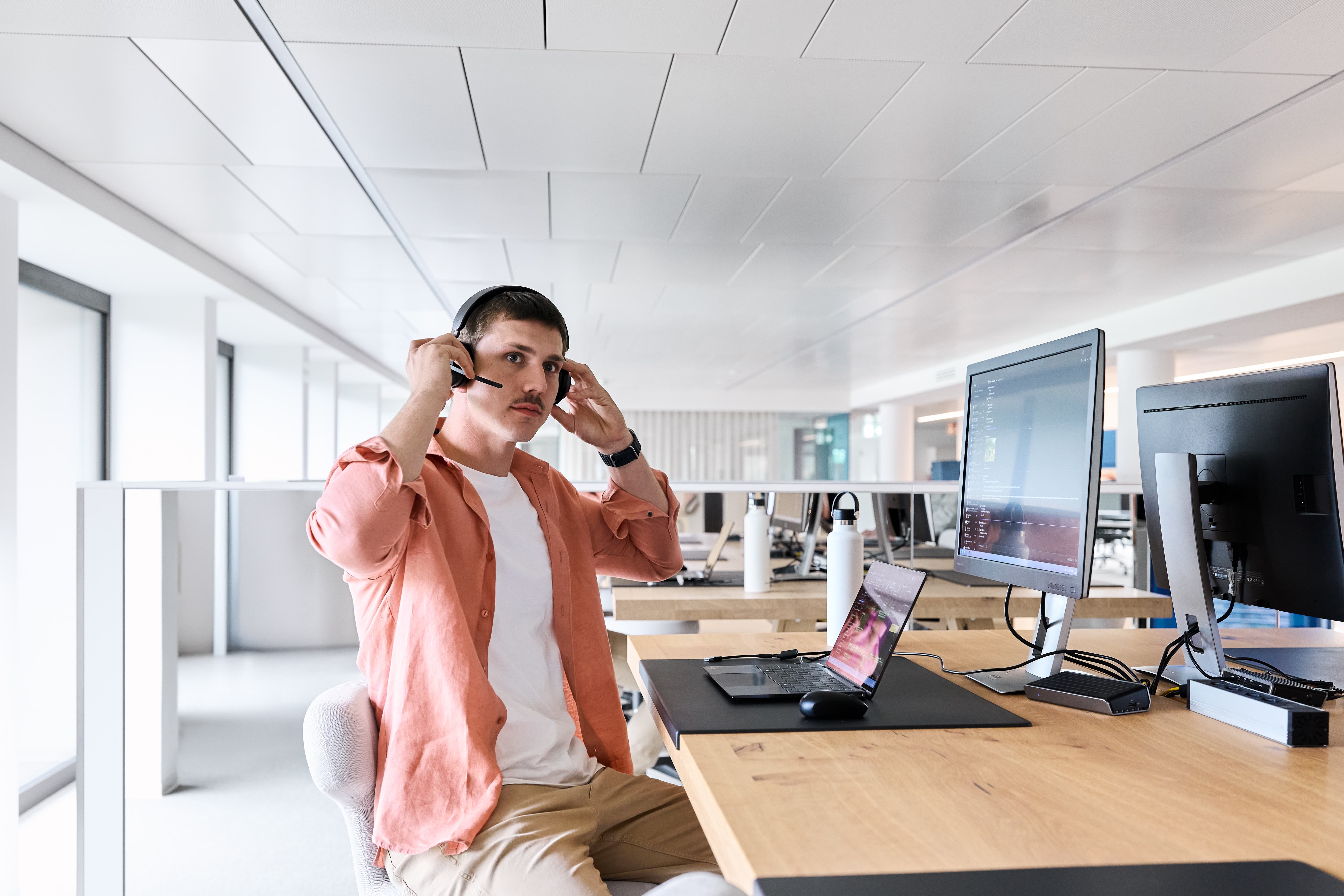 La femme est assise à son poste de travail et téléphone.