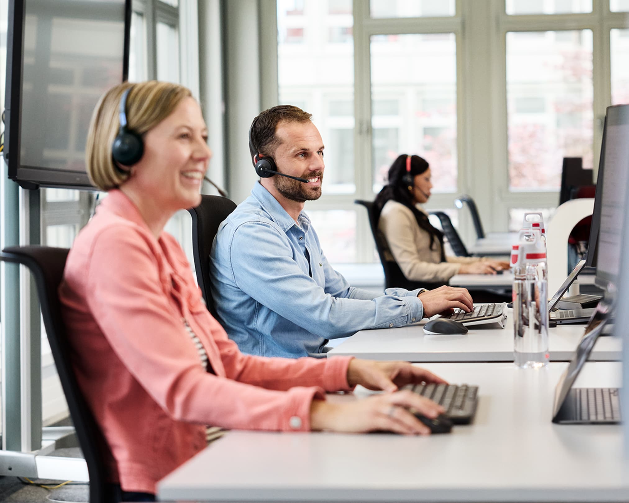 Mann telefoniert mit Headset am Computer