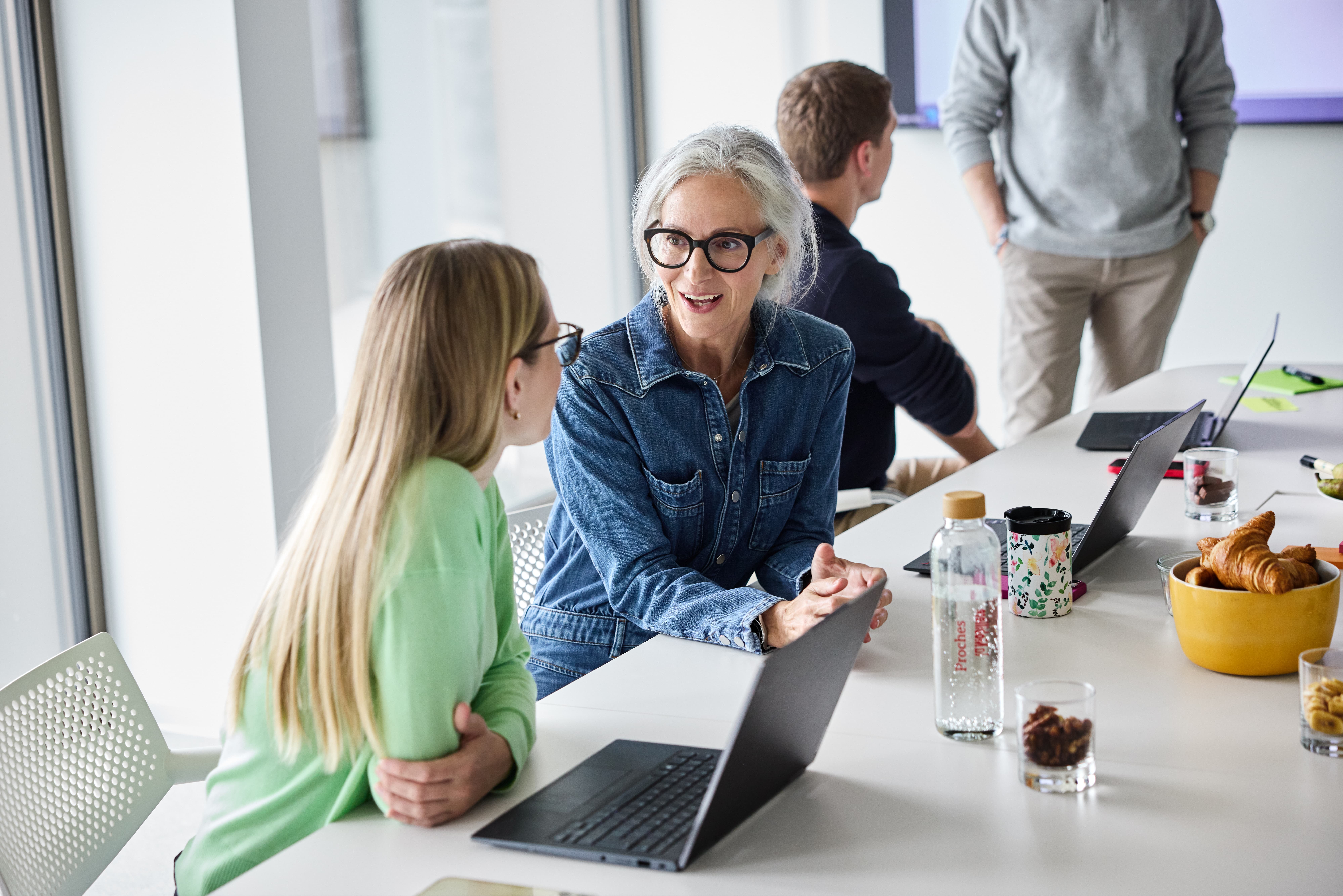 Mitarbeitende am Diskutieren in einem Büro