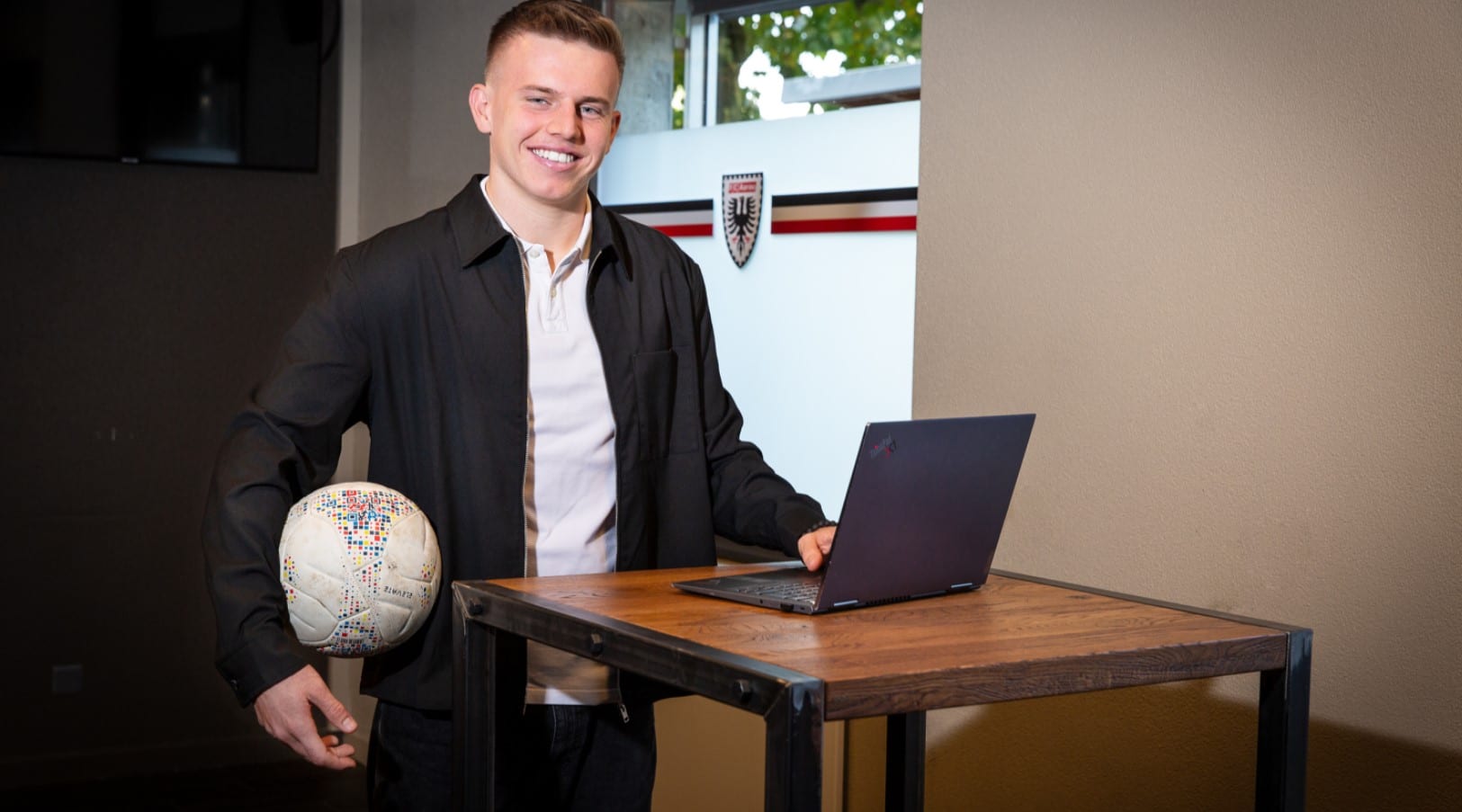 Portrait von Robin Locher mit Fussball und Laptop