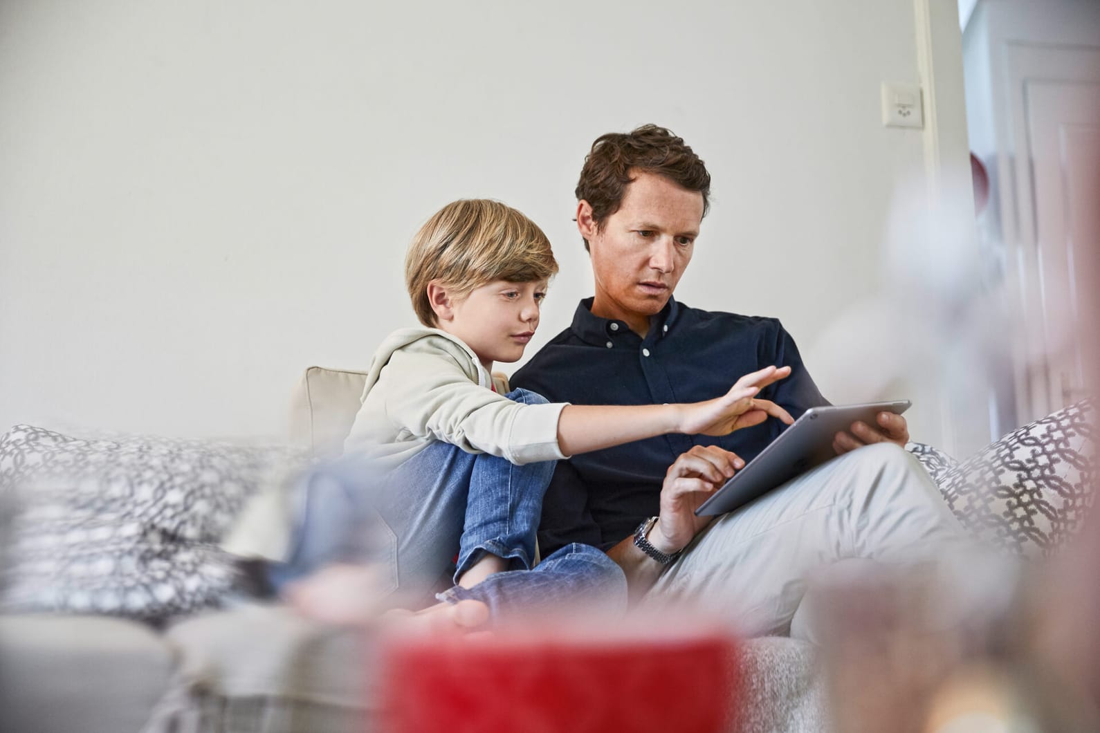 Un père et son fils font du shopping en ligne sur le canapé