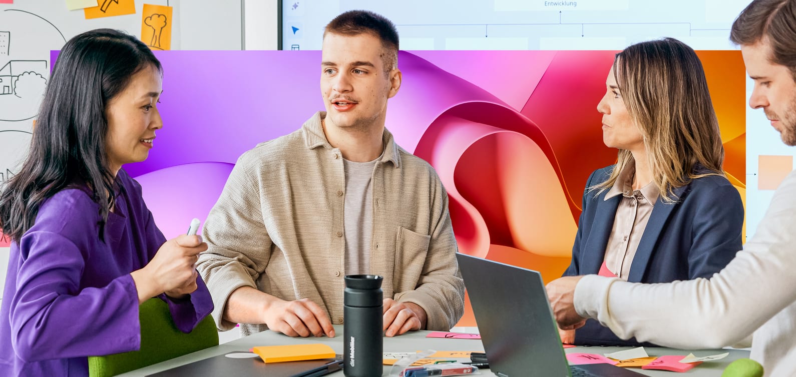 Junge Mitarbeitende im Teamwork mit Laptop und Whiteboard