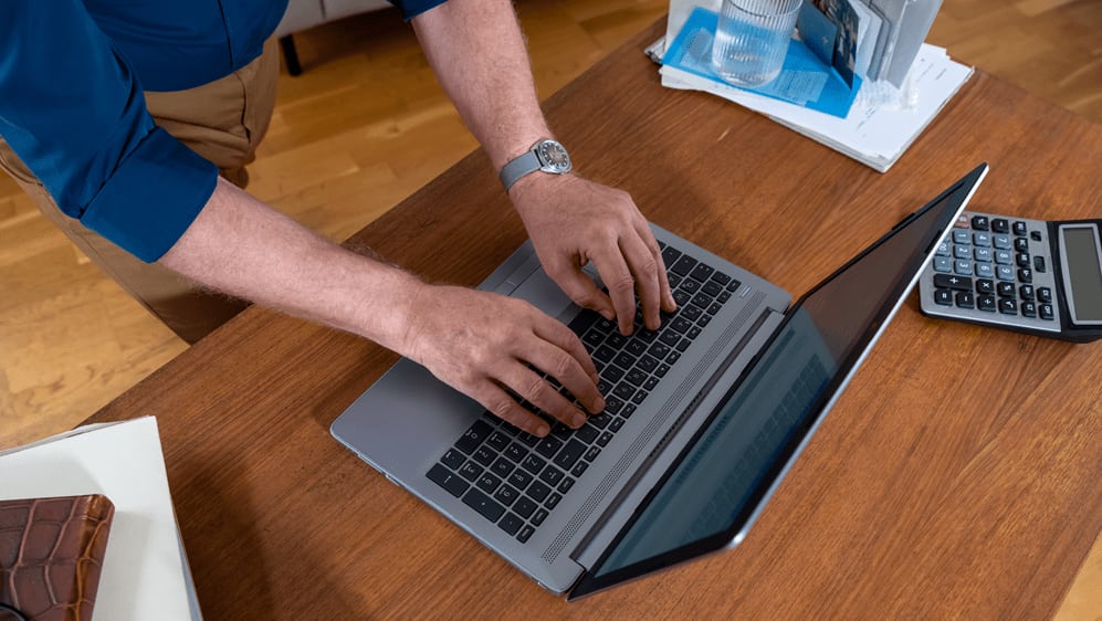 Frau tippt auf einem Laptop.