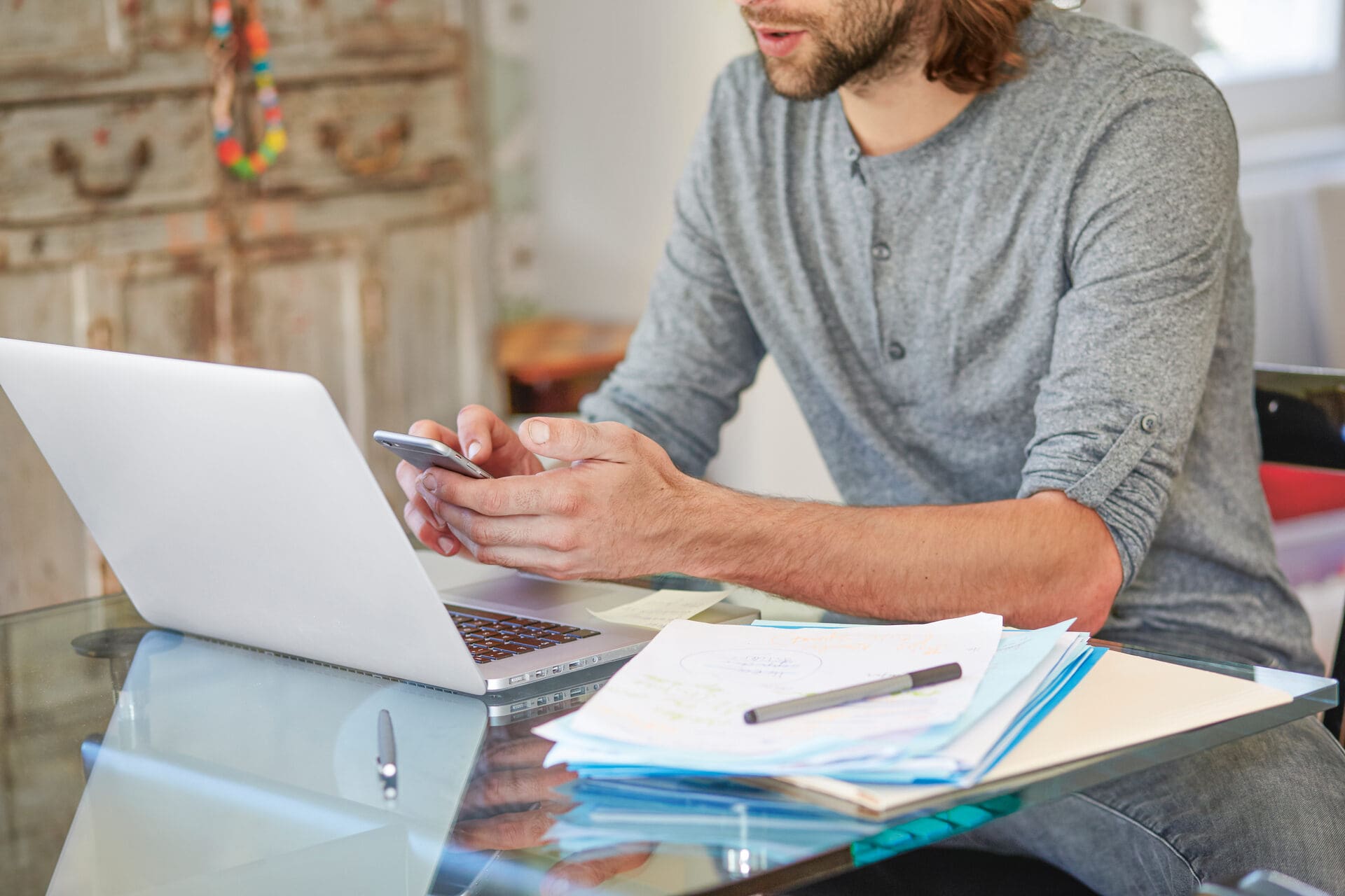 Mann arbeitet am Laptop und Smartphone