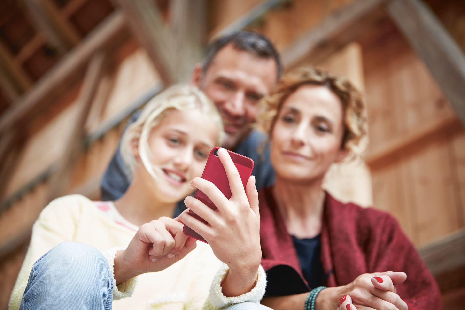 Un bambino mostra ai genitori qualcosa sul loro cellulare.