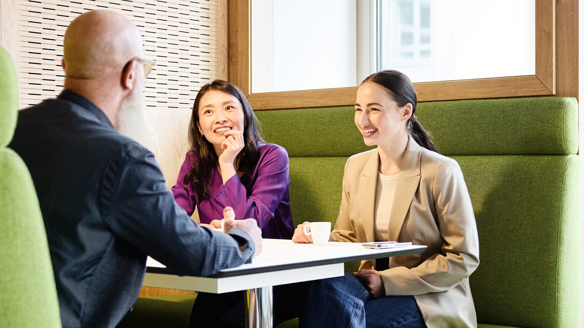 drei Personen unterhalten sich am Tisch