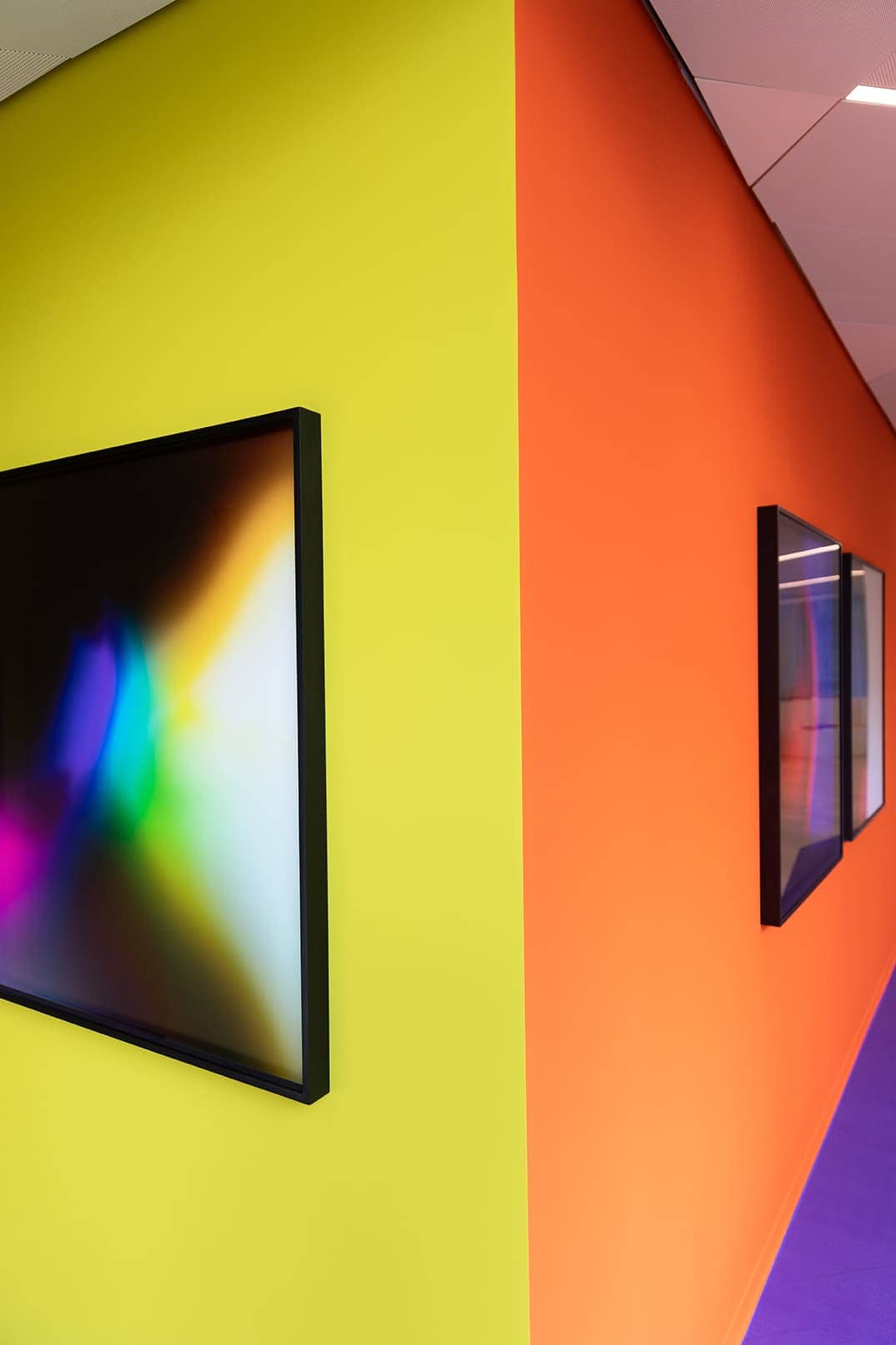 deux tableaux sur un mur jaune et un mur orange dans le cadre de l’exposition «L’art et le développement durable à la Mobilière»