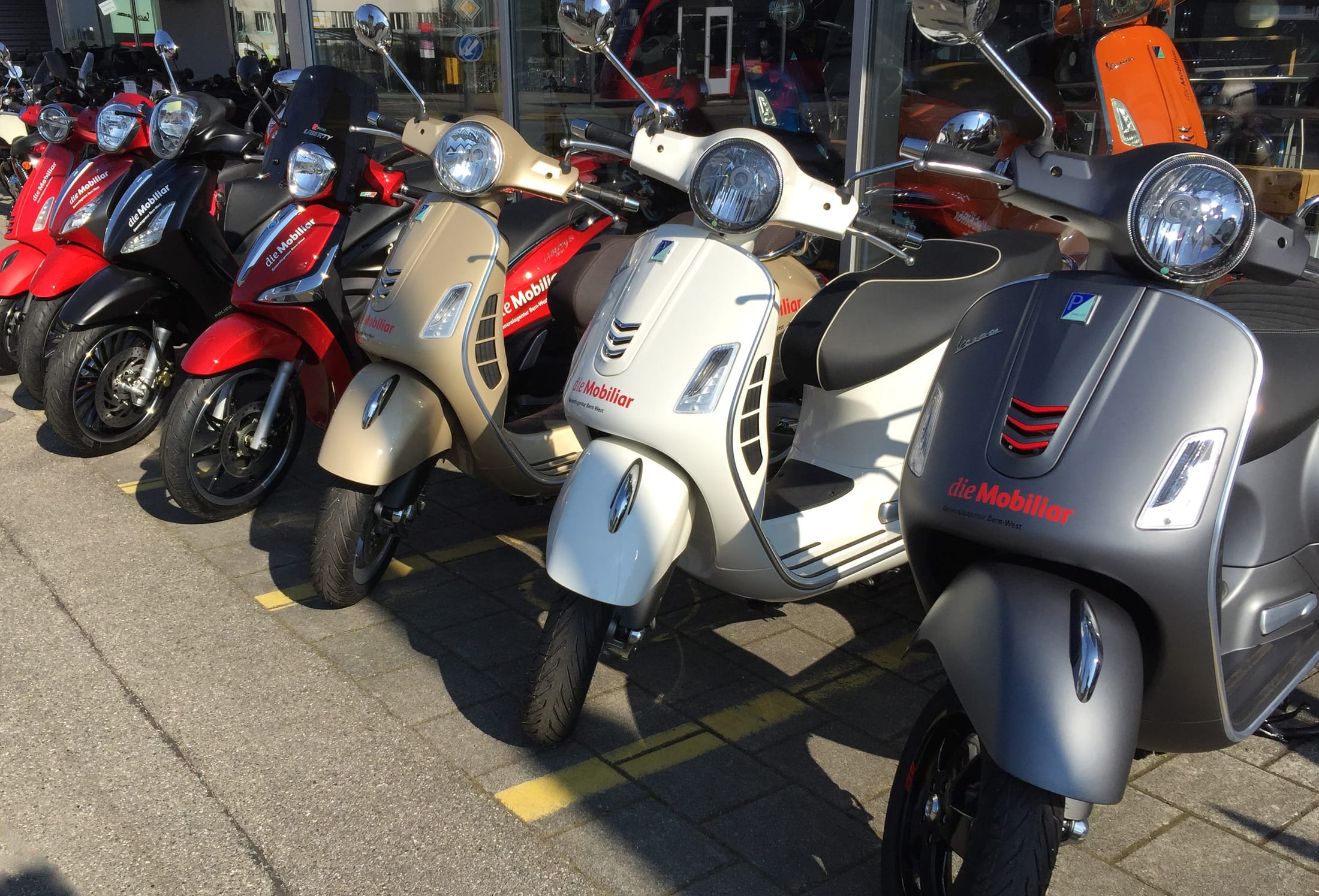 Verschiedene Roller stehen vor der Mobiliar Agentur.