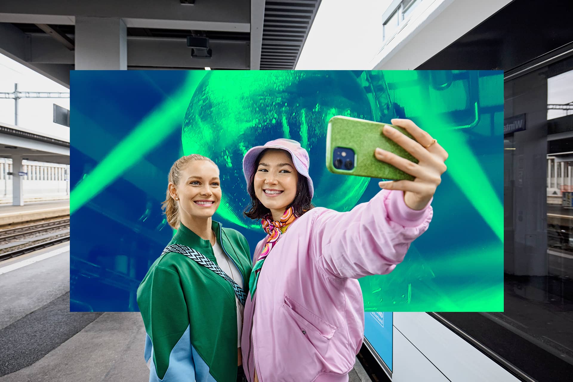 Des jeunes femmes prennent un selfie à la gare.